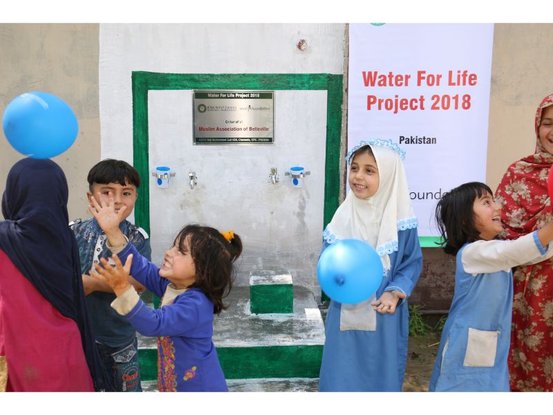 Schoolchildren beside a Water for Life well in Pakistan